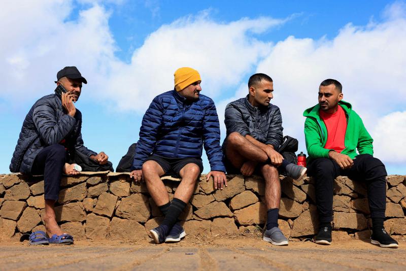 (स्पेनको टेनेरिफ टापुमा रहेको ला लागुनामा रहेको लास राइसेस आप्रवासी शिविर बाहिर बसिरहेका पाकिस्तानी आप्रवासीहरू)
