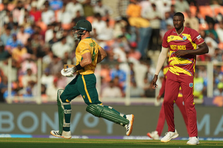 West Indies' Jason Holder, right, looks on as South Africa's captain Aiden Markram runs between the wickets during the T20 World Cup cricket match between South Africa and West Indies in Ahmedabad, India, Thursday, Feb. 26, 2026. (AP Photo/Ajit Solanki)